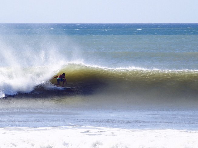 Surfer getting barreled in a left hand wave in front of El Ranchito Panama Surf Camp