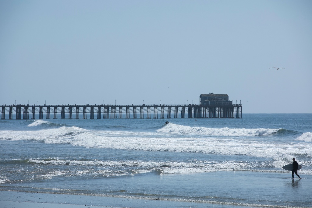 Oceanside pier in the background with Oceanside surf in the foreground