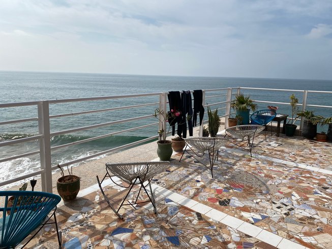 Patio with chairs and wetsuits overlooking the ocean in Taghazout, Morocco
